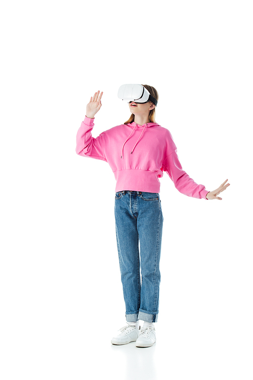 excited teenage girl in pink hoodie and jeans wearing vr headset isolated on white