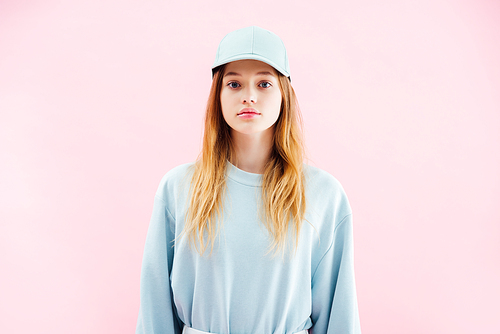 sad pretty teenage girl in cap  isolated on pink