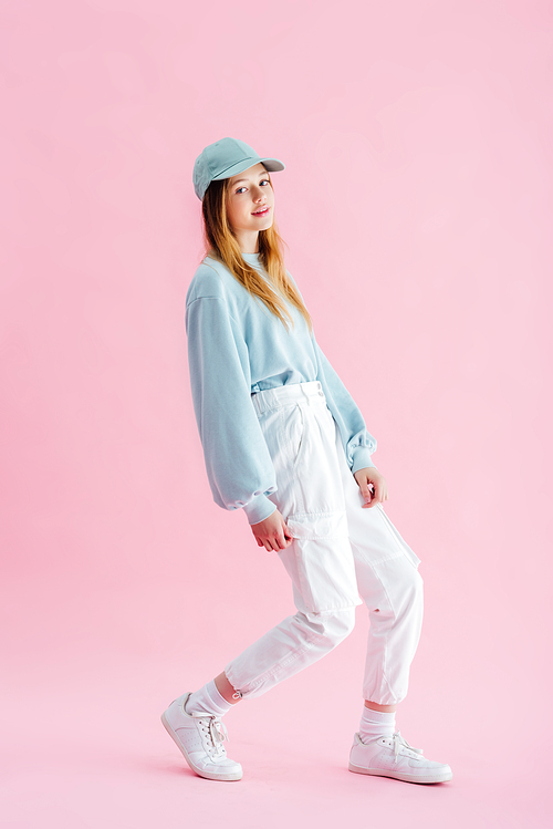 stylish pretty teenage girl in cap  on pink