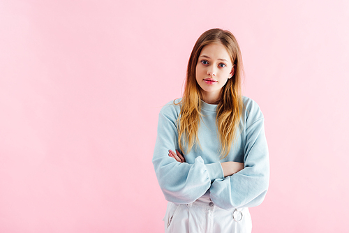 offended teenage girl with crossed arms isolated on pink