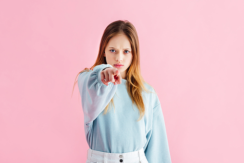 sad teenage girl pointing with finger at camera isolated on pink