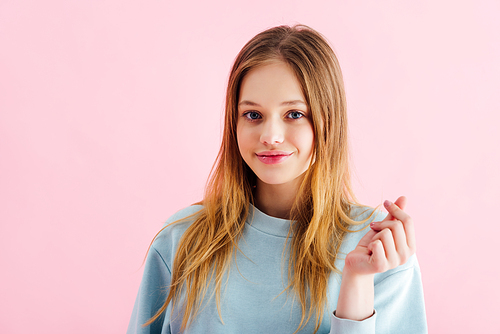 happy pretty teenage girl snapping fingers isolated on pink