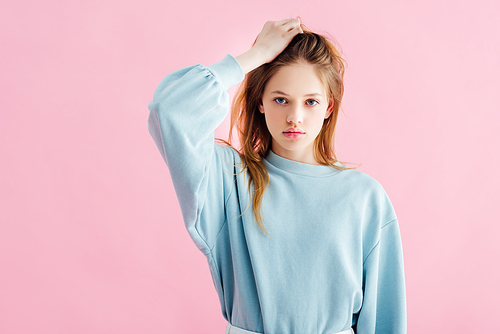 sad pretty teenage girl touching head isolated on pink