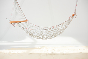 hanging hammock made of net over sand on grey