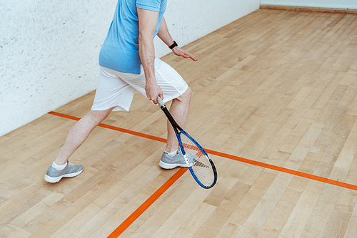 Cropped view of sportsman in white shorts playing squash