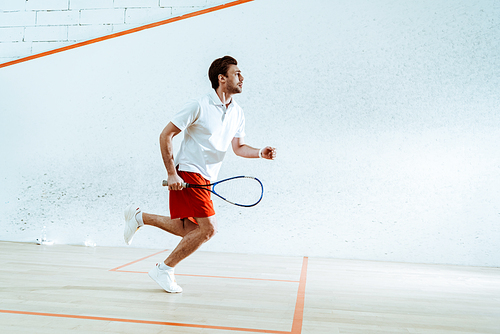 Full length view of sportsman with racket running while playing squash