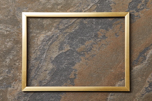 empty golden frame on stone background with copy space