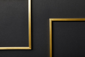 top view of empty golden frames on black background with copy space
