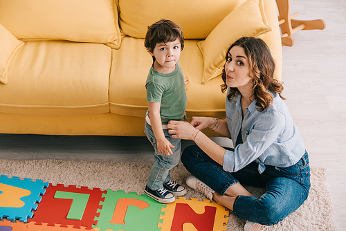 mother and son with alphabet puzzle mat in living room