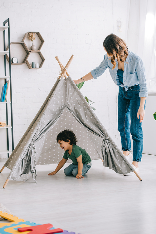 Full length view of woman standing near son in grey wigwam