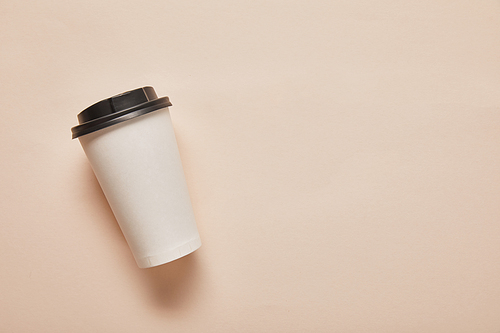 top view of paper cup with copy space on beige background