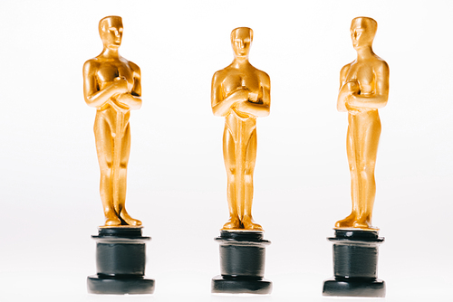 shiny golden oscar statuettes isolated on white