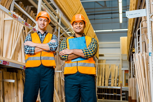 cheerful multicultural workers with crossed arms smiling and