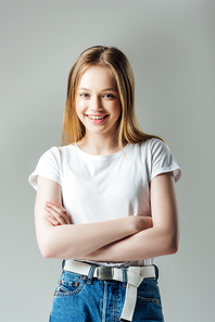 happy teenage girl with crossed arms  isolated on grey