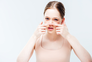 displeased teenage girl having acne on nose isolated on grey