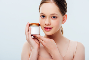 smiling teenage girl holding container with cosmetic cream isolated on grey