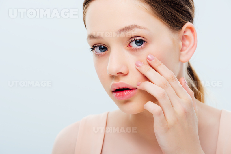 유토이미지 | displeased teenage girl touching face isolated on grey