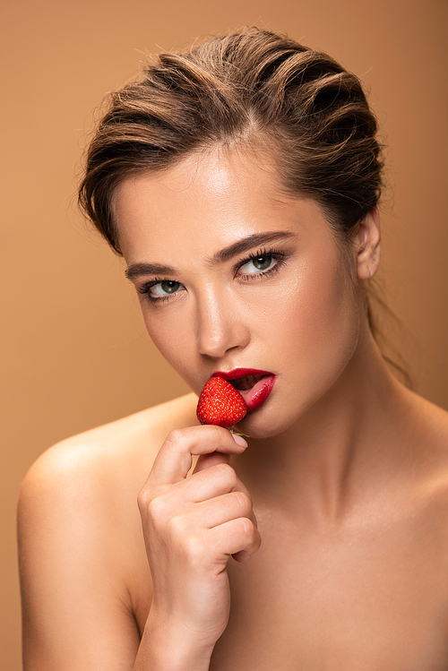 naked beautiful woman holding strawberry and  isolated on beige