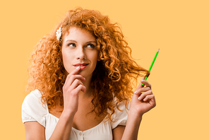attractive thoughtful woman with pencil isolated on yellow