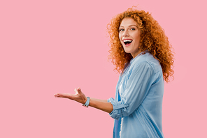 smiling redhead woman gesturing Isolated On pink