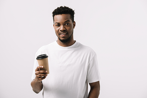 curly and happy african american man holding paper cup isolated on white