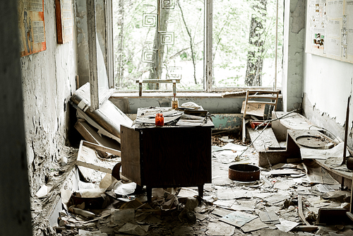 abandoned and damaged room with papers and documents on floor