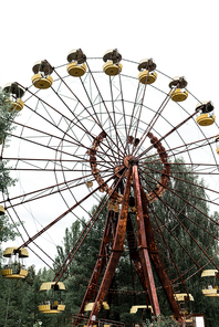 abandoned and rusty carousel in amusement park with trees against sky