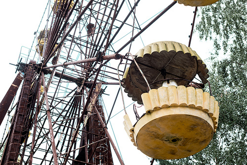low angle view of metallic ferris wheel in amusement park against sky