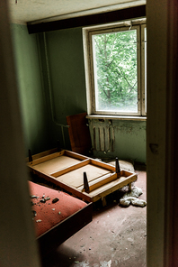 selective focus of wooden table in dirty room in chernobyl