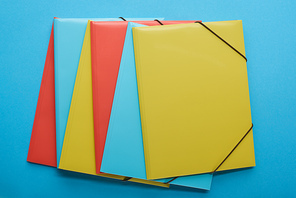 top view of arranged red, blue and yellow paper binders
