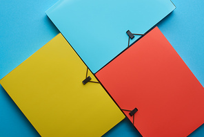 top view of arranged colorful paper folders on blue