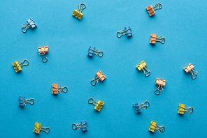 top view of colorful paper clips isolated on blue
