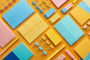 flat lay of colorful arranged office stationery supplies on yellow