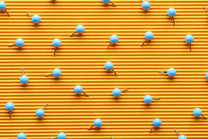 top view of push pins on textured yellow paper