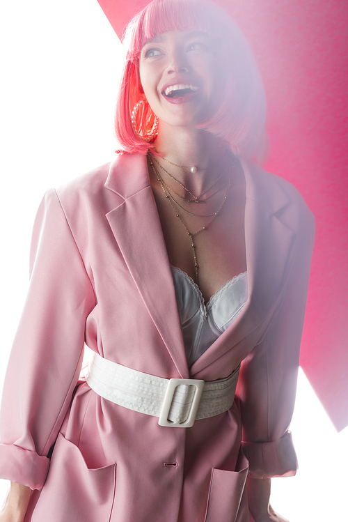 happy and stylish woman laughing on white and pink
