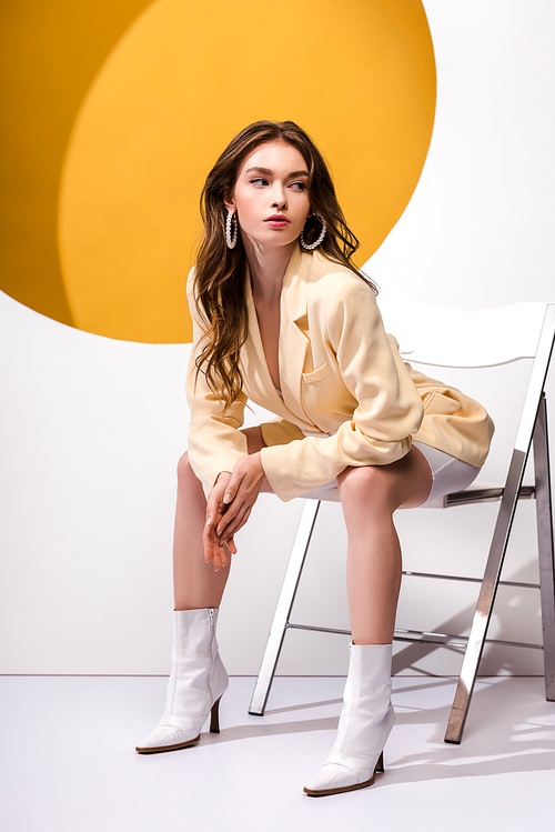 beautiful girl sitting on chair on white and orange