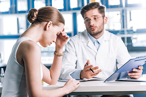 selective focus of upset woman sitting near allergist in clinic