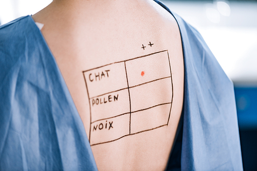 cropped view of woman with lettering and marks on back