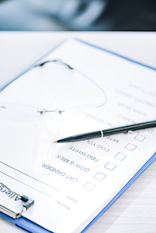 selective focus of pen near clipboard with checklist in clinic