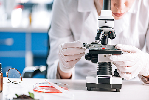 cropped view of immunologist looking through microscope