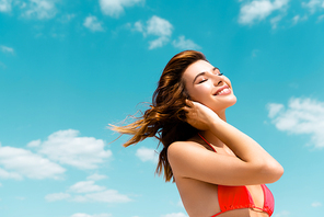 happy beautiful sexy girl in swimsuit on blue sky with clouds background