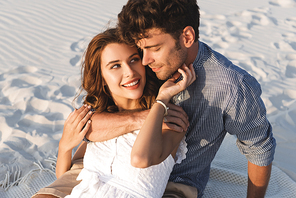 smiling young couple hugging on beach