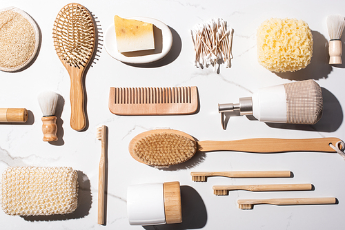 Top view of comb, ear sticks, sponges, Hair brushes, liquid soap dispenser, shaving brushes, toothbrushes on white background, zero waste concept
