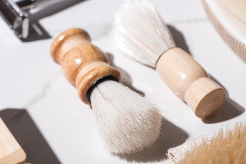 Selective focus of shaving brushes on white background, zero waste concept
