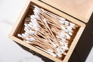 Top view of opened box with ear sticks on white background, zero waste concept