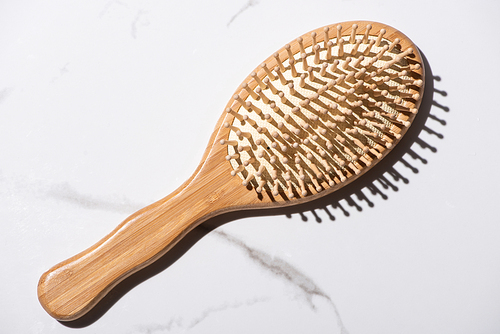 Top view of wooden hair brush on white background, zero waste concept