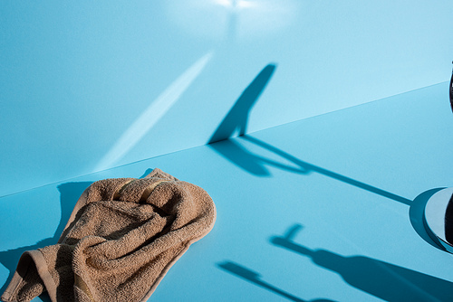 Towel and shadows on blue background, zero waste concept