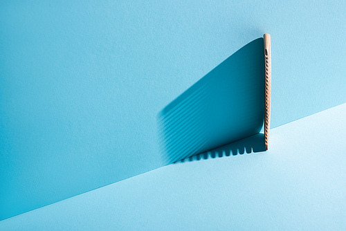 Comb with shadow on blue background, zero waste concept