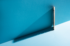 Wooden comb on blue background, zero waste concept