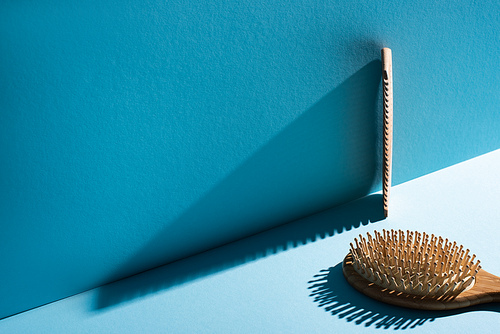 Comb and hair brush on blue background, zero waste concept